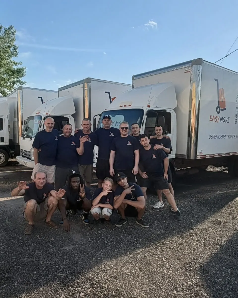 L'équipe d'Easy Move, une douzaine de déménageurs en t-shirt marine, devant ses camions au logo Easy Move — photo réelle